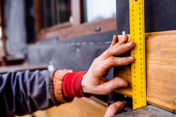 Рука неузнаваемого рабочего, делающего фасад, измеряющего деревянное бо — стоковое фото