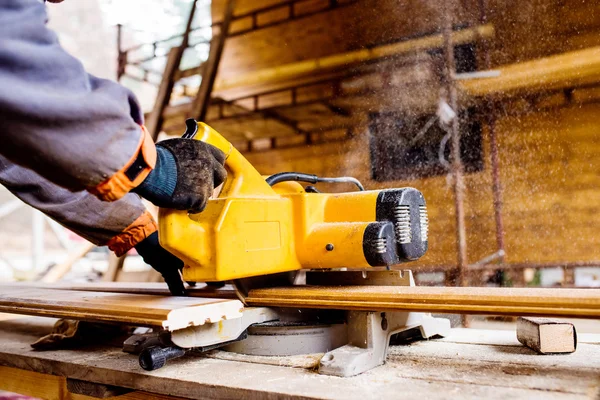 Zimmermannsarbeit. Mann sägt Bohlen mit Kreissäge. — Stockfoto