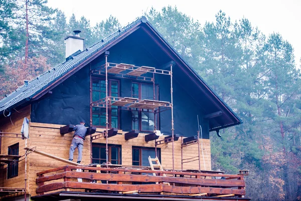 Construction worker thermally insulating house, doing wooden fac — Stock Image Construction worker thermally insulating house, doing wooden fac Stock Image