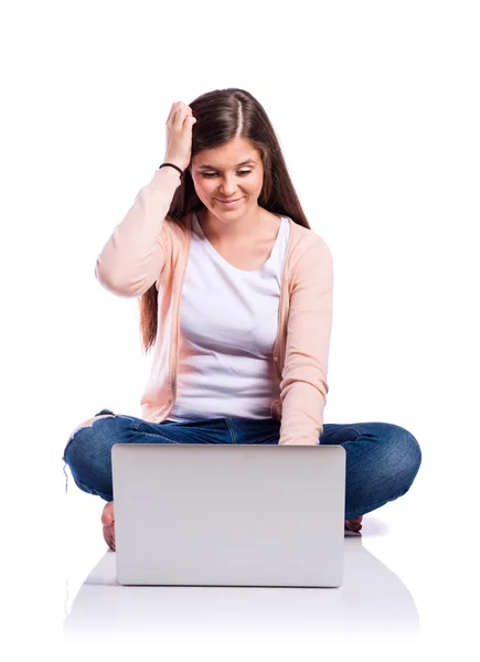 Vrouw met laptop zittend op de vloer, studio opname, geïsoleerd — Stockfoto