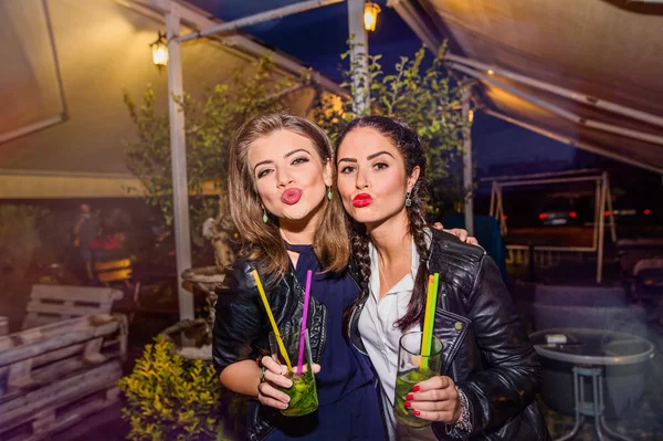 Unga vackra kvinnor med cocktails i bar eller klubb — Stockfoto