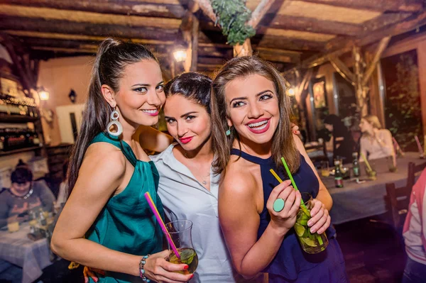 Giovani belle donne con cocktail in bar o club — Foto Stock