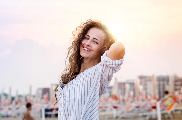 Vacker kvinna på strand i vit skjorta, leende, solnedgång — Stockfoto