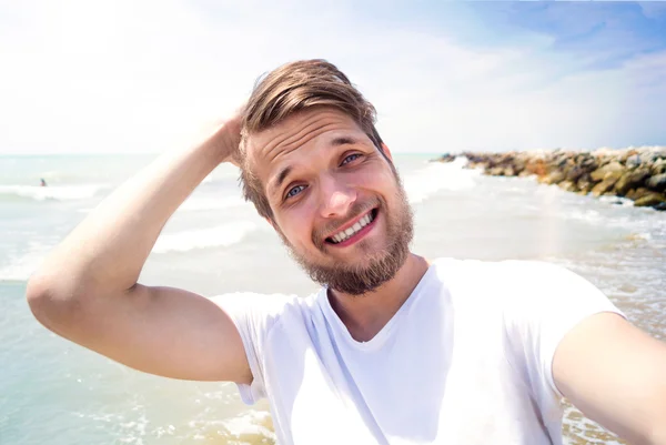 Hipster man on beach, smiling, taking selfie, sunny summer — Stock Photo, Image