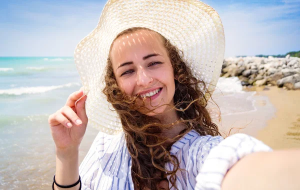 Vacker kvinna på stranden, leende, med selfie, solig dag — Stockfoto