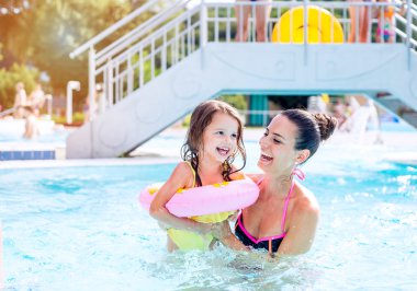 Anne ve kızı Yüzme Havuzu, aquapark. Güneşli yaz.
