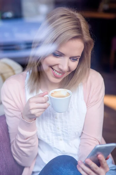 Oigenkännlig kvinna med smartphone i café dricker kaffe — Stockfoto