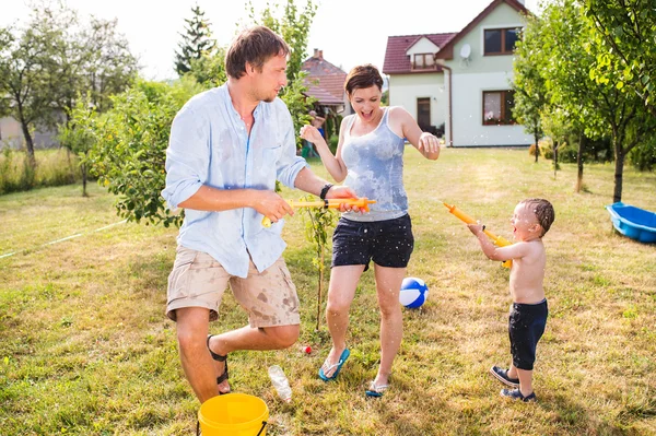 Liten pojke med mor och far stänk varandra — Stockfoto