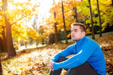 Güneşli sonbahar doğa dışarıda genç yakışıklı hipster runner