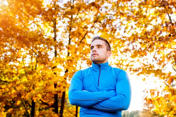 Young handsome hipster runner outside in sunny autumn nature — Stock Photo, Image