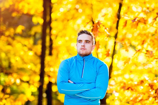 Young handsome hipster runner outside in sunny autumn nature — Stock Photo, Image