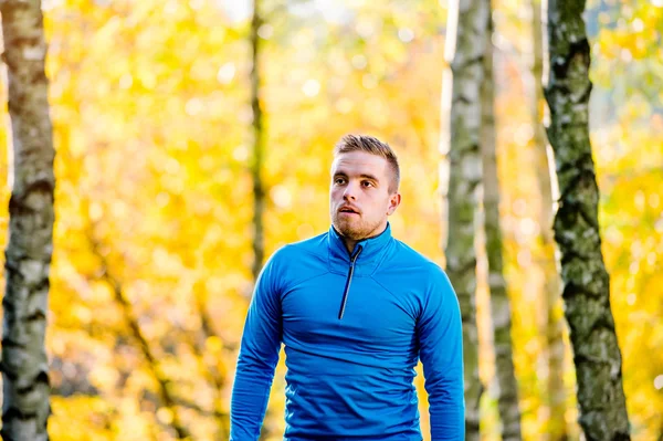 Jonge knappe hipster loper buiten in de zonnige herfst natuur — Stockfoto