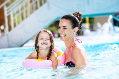 Anne ve kızı Yüzme Havuzu, aquapark. Güneşli yaz.