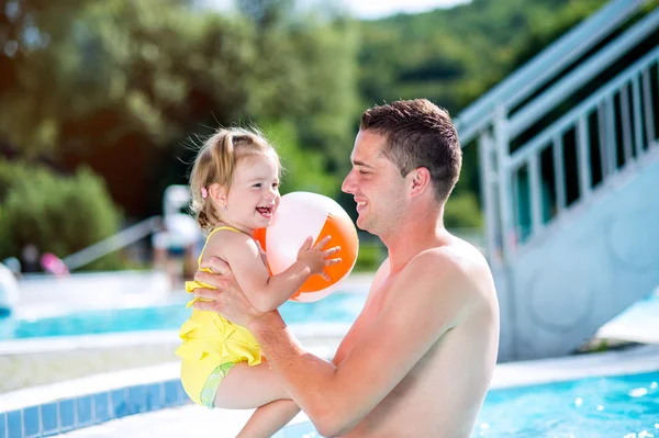 父亲和他的女儿在游泳池里。阳光灿烂的夏天. — 图库照片
