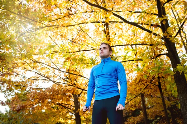 Young athlete running in autumn nature — Stock Photo, Image