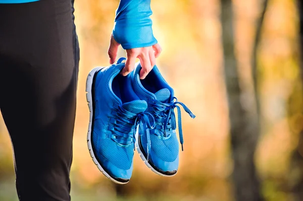 Young runner holding sport shoes — Stock Photo, Image