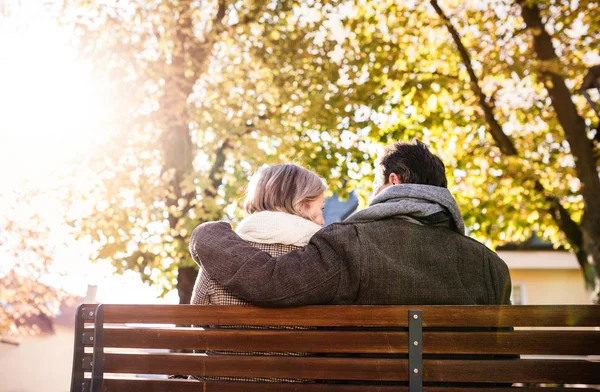 Äldre par på bänken under hösten — Stockfoto