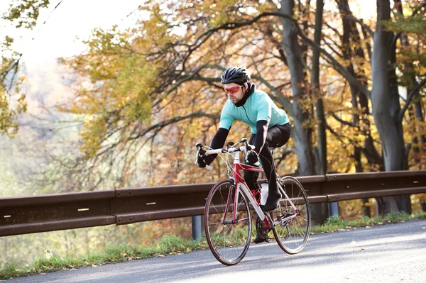 运动员在秋天骑他的自行车 — 图库照片