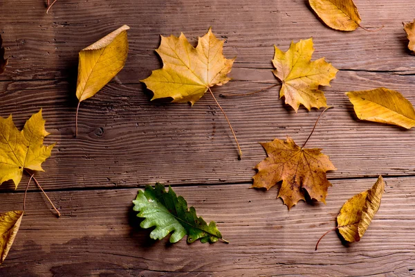 Композиція осіннього листя на дерев'яному фоні . — стокове фото
