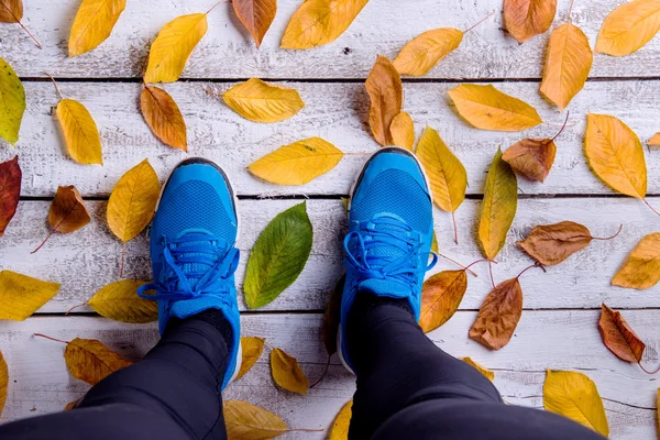 Jambes de coureur et feuilles d'automne . — Photo