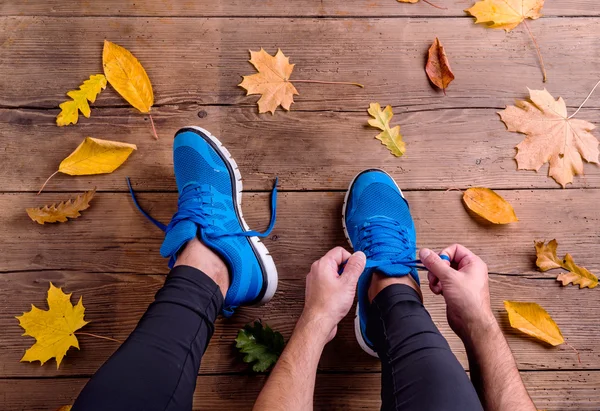 Běžec ve sportovní obuvi, vázání tkaničky. — Stock fotografie