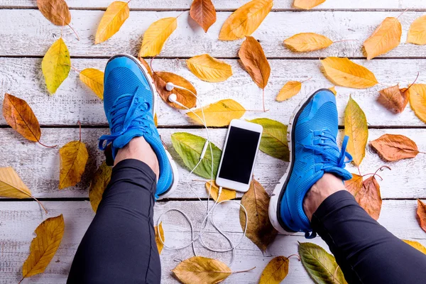 Spor ayakkabı koşucu. Akıllı telefon ve kulaklık. — Stok fotoğraf