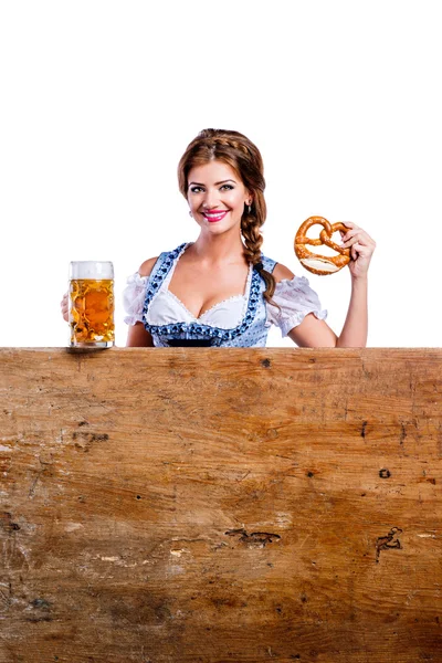 Woman in bavarian dress with pretzel and beer — Stock fotografie
