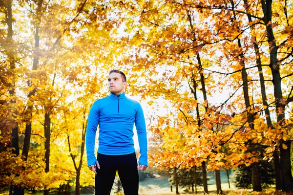 Jongeman runner in de herfst natuur — Stockfoto