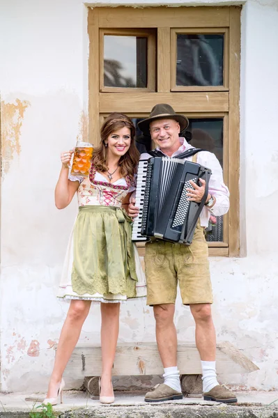 Casal em roupas bávaras com cerveja e acordeão — Fotografia de Stock