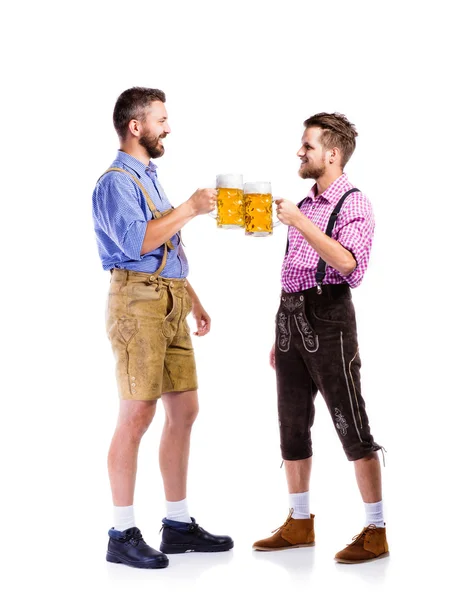 Мужчины в баварской одежде с кружками пива — стоковое фото