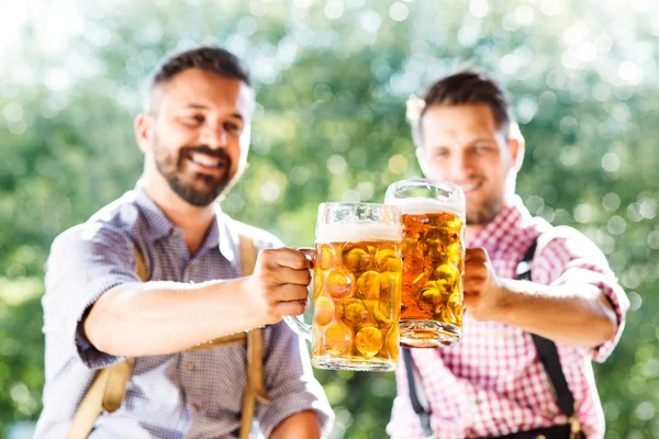Män i bayerska kläder med muggar av öl — Stockfoto