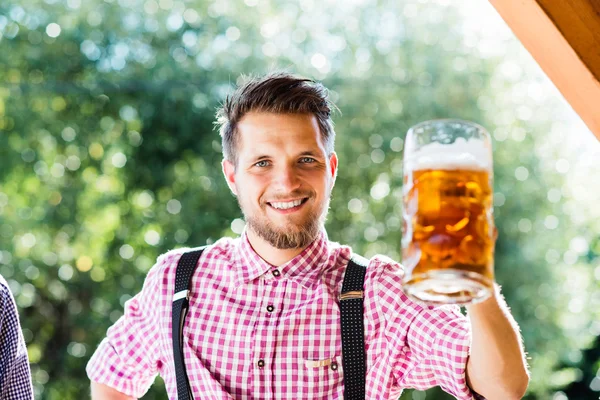 Άνθρωπος στα Βαυαρικά ρούχα κρατώντας κούπα μπύρας — Φωτογραφία Αρχείου