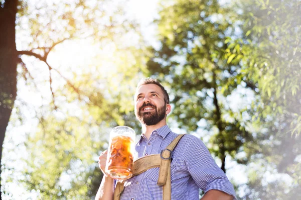 Hombre con ropa bavariana sosteniendo jarra de cerveza —  Fotos de Stock