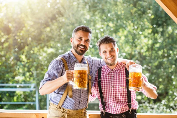 Férfiak bajor ruhák bögre sör — Stock Fotó