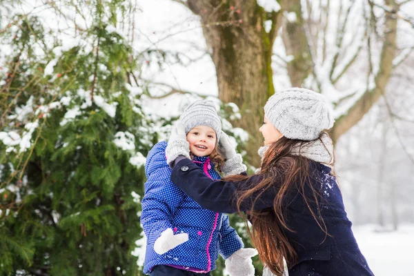 Mor med dottern spelar utanför i vinter natur — Stockfoto
