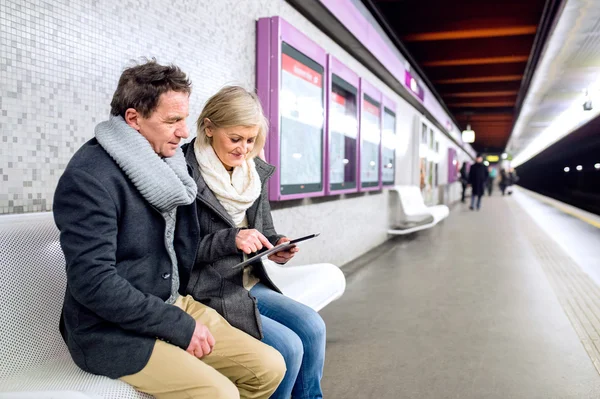 Seniorenpaar sitzt am U-Bahnsteig und wartet — Stockfoto