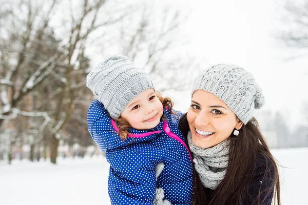 Madre con su hija abrazándose al aire libre en invierno naturaleza —  Fotos de Stock