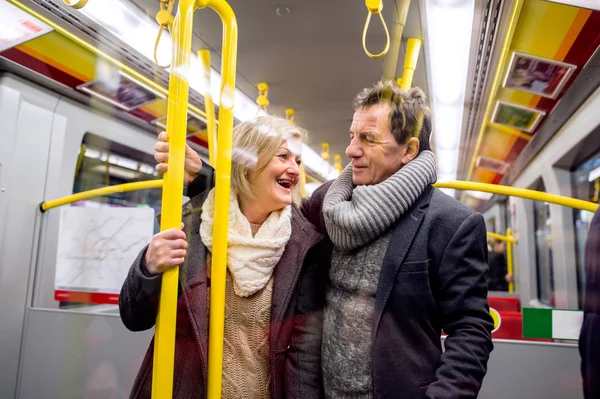 Casal de idosos de pé em um trem de metrô lotado — Fotografia de Stock