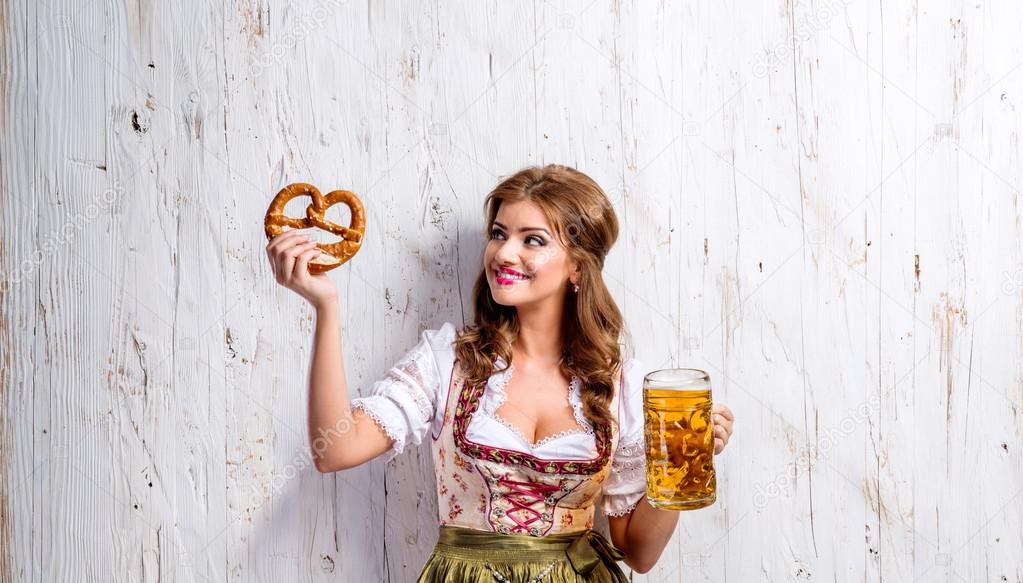 Woman in bavarian dress with beer and pretzel