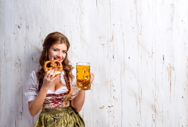 Žena v bavorské šaty s pivem a preclík — Stock fotografie