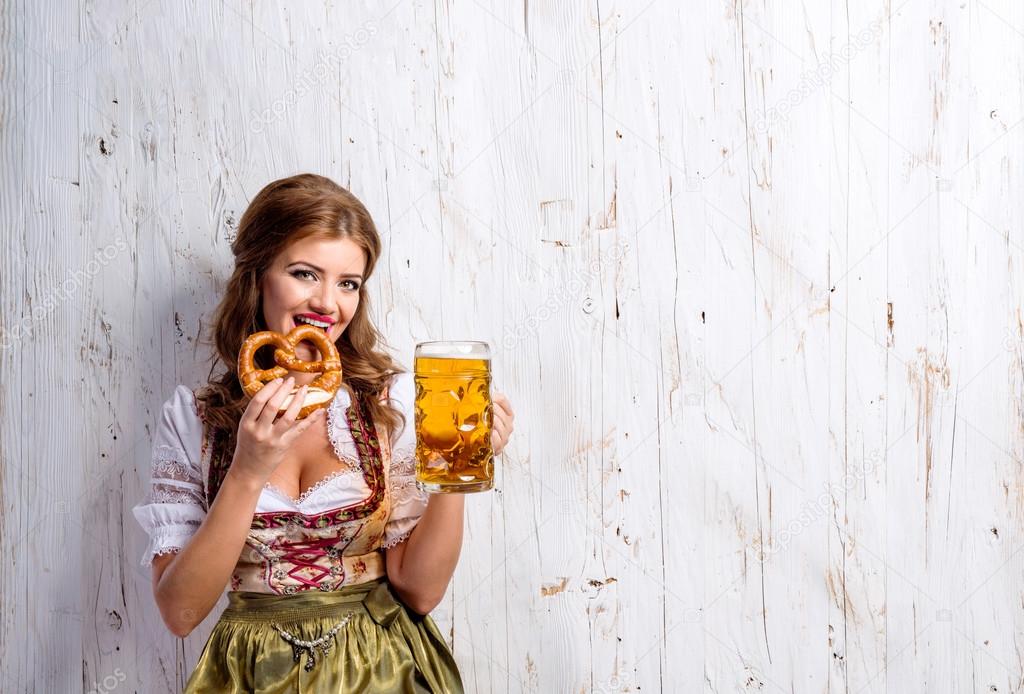 Woman in bavarian dress with beer and pretzel