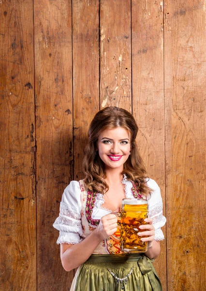 Geleneksel Bavyera kıyafetli kadın elinde bira tutuyor — Stok fotoğraf