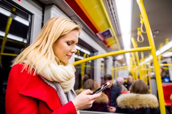Beautiful young woman with smart phone in subway train — Stock Photo, Image