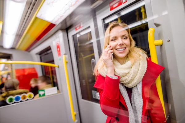 Красива молода жінка зі смартфоном у поїзді метро — стокове фото