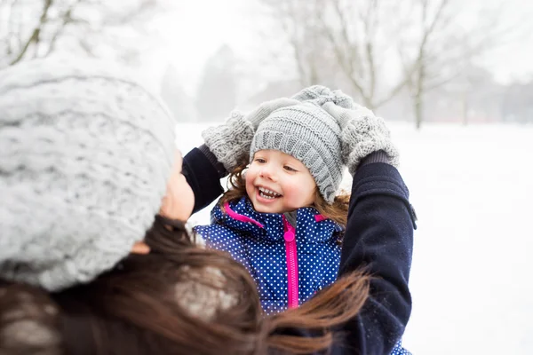 Mor med dottern spelar utanför i vinter natur — Stockfoto