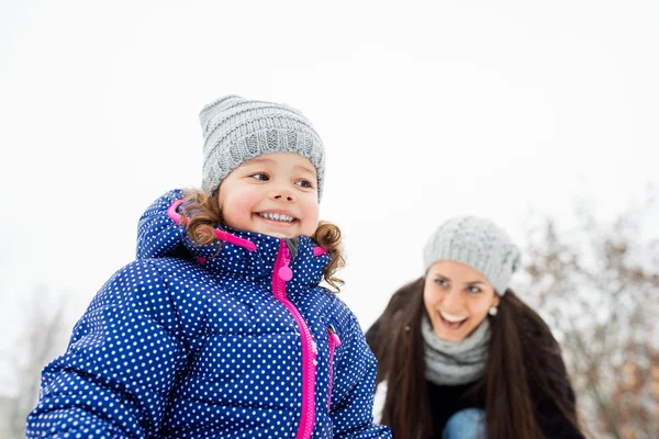 Mãe com sua filha brincando fora no inverno natureza — Fotografia de Stock