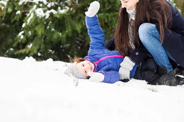 Mor med dottern spelar utanför i vinter natur — Stockfoto