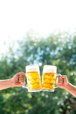 İki adamın bira kupaları tutan eller