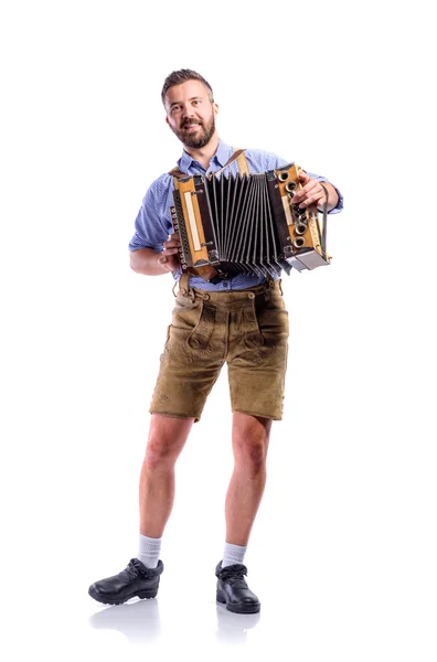 Людина в традиційному баварському одяг розриває акордеон на шматки. Oktoberfe — стокове фото