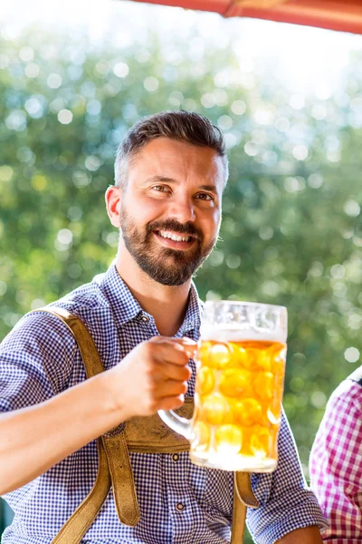 Ο άνθρωπος σε παραδοσιακό βαυαρικό ρούχα κρατώντας κούπα της μπύρας — Φωτογραφία Αρχείου